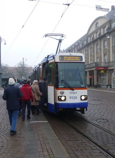 Straßenbahn-Triebwagen 9120 der Darmstädter Straßenbahn, benannt nach der ungarischen Partnerstadt Szeged, hält am Hauptbahnhof. Hersteller: Waggon Union, Baujahr 1990. Von diesen Hochflurfahrzeugen sind in Darmstadt noch mehrere in Betrieb, stets gemeinsam mit einem Niederflur-Beiwagen, um Barrierefreiheit zu gewährleisten.