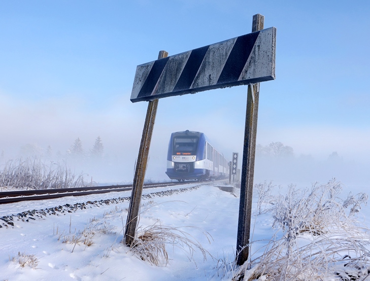 Tief winterlich zeigt sich das Wetter am 18.12.2022 bei Warngau. Ein BRB-Zug ist in Richtung SÃ¼den unterwegs und hat mit Sicherheit viele Wintersportler an Bord.