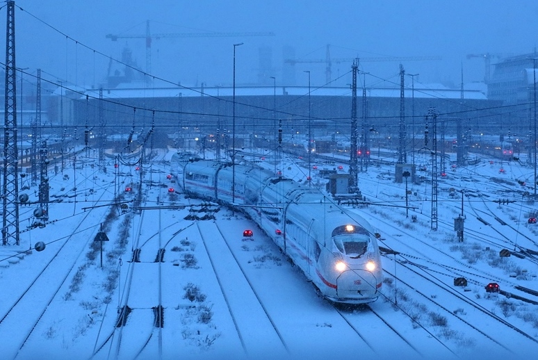 Tief winterliche VerhÃ¤ltnisse: In der AbenddÃ¤mmerung des 21.01.2023 verlÃ¤sst ein ICE-3 neo den MÃ¼nchner Hauptbahnhof