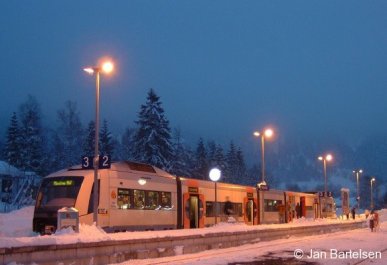 Im winterlich verschneiten und abendlichen Bayrischzell wartet ein Triebwagen vom Typ 