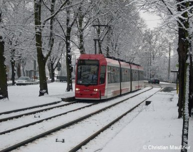 Straßenbahnzug 1107 hat am 12.12.2008 im verschneiten Nürnberg gerade die Haltestelle Am Rangierbahnhof verlassen.