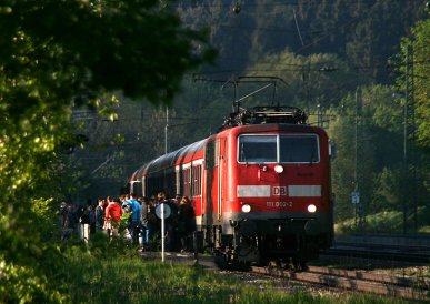 111 002 hält mit einem gut besetzten Pendlerzug am 6.05.2011 in Aßling.