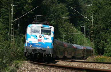 In der Mittagshitze des 23.08.2011 ist Bahnland Bayern-Lok 111 017 mit einem Regionalzug von München nach Salzburg unterwegs, aufgenommen zwischen Grafing und Aßling.