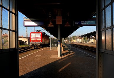Bahnsteigblick mit einem durchfahrenden Güterzug in Riesa am 24.04.2019